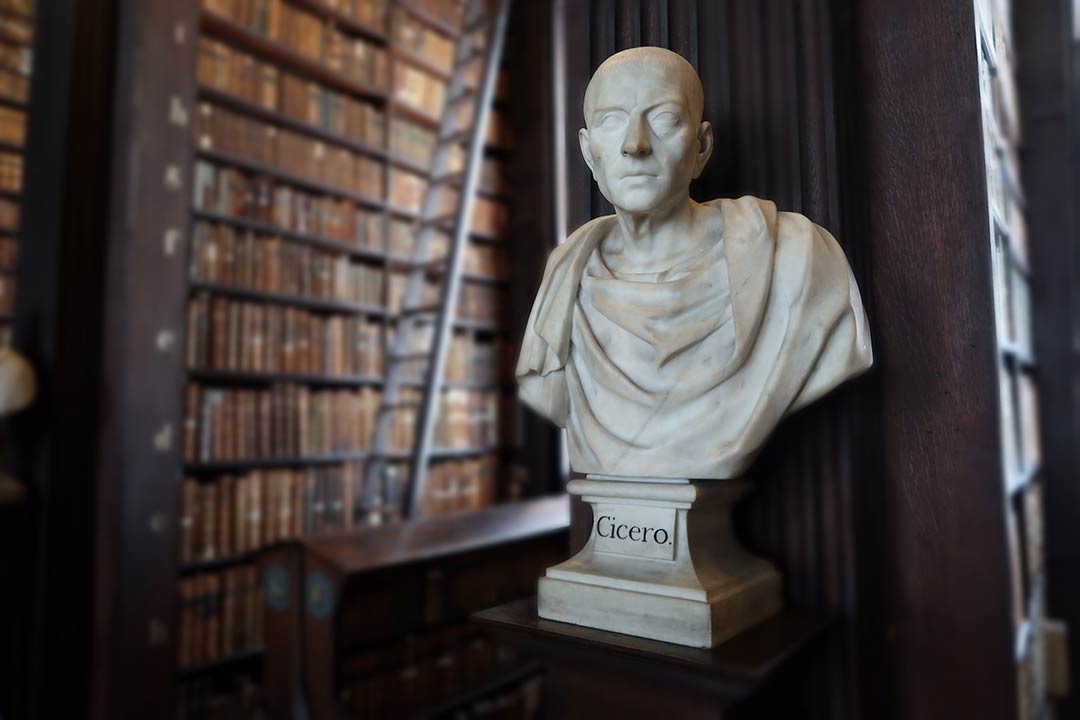 White marble bust of Cicero with the Trinity College Library, Dublin, in the background.